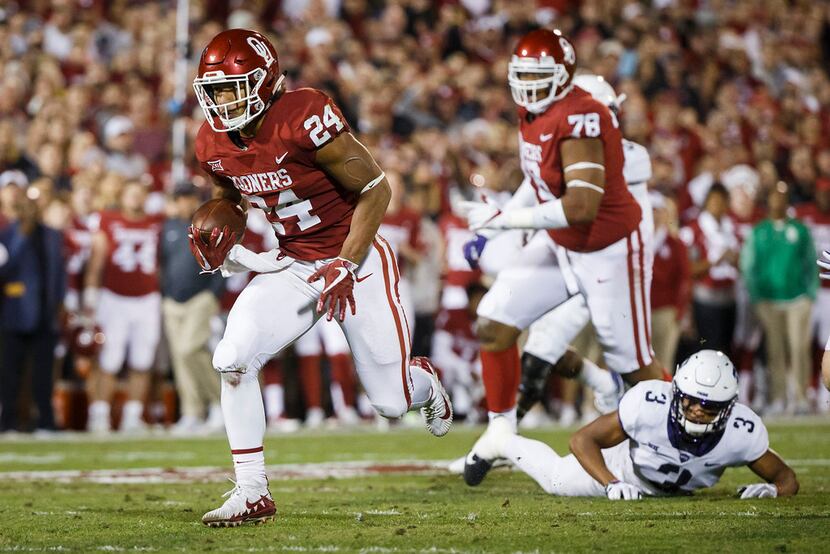Oklahoma running back Rodney Anderson (24) gets past TCU safety Markell Simmons (3) on a...