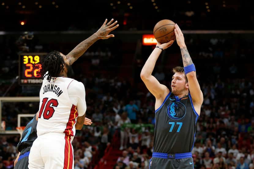 Dallas Mavericks forward Luka Doncic (77) shoots the ball against Miami Heat forward James...