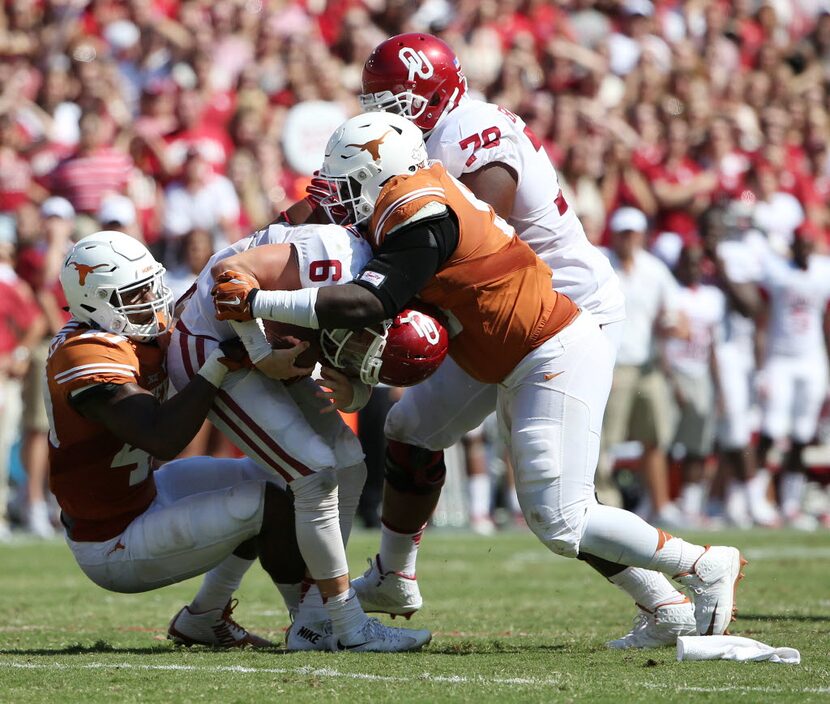 Texas Longhorns defensive end Naashon Hughes (40) and defensive tackle Poona Ford (95) sack...