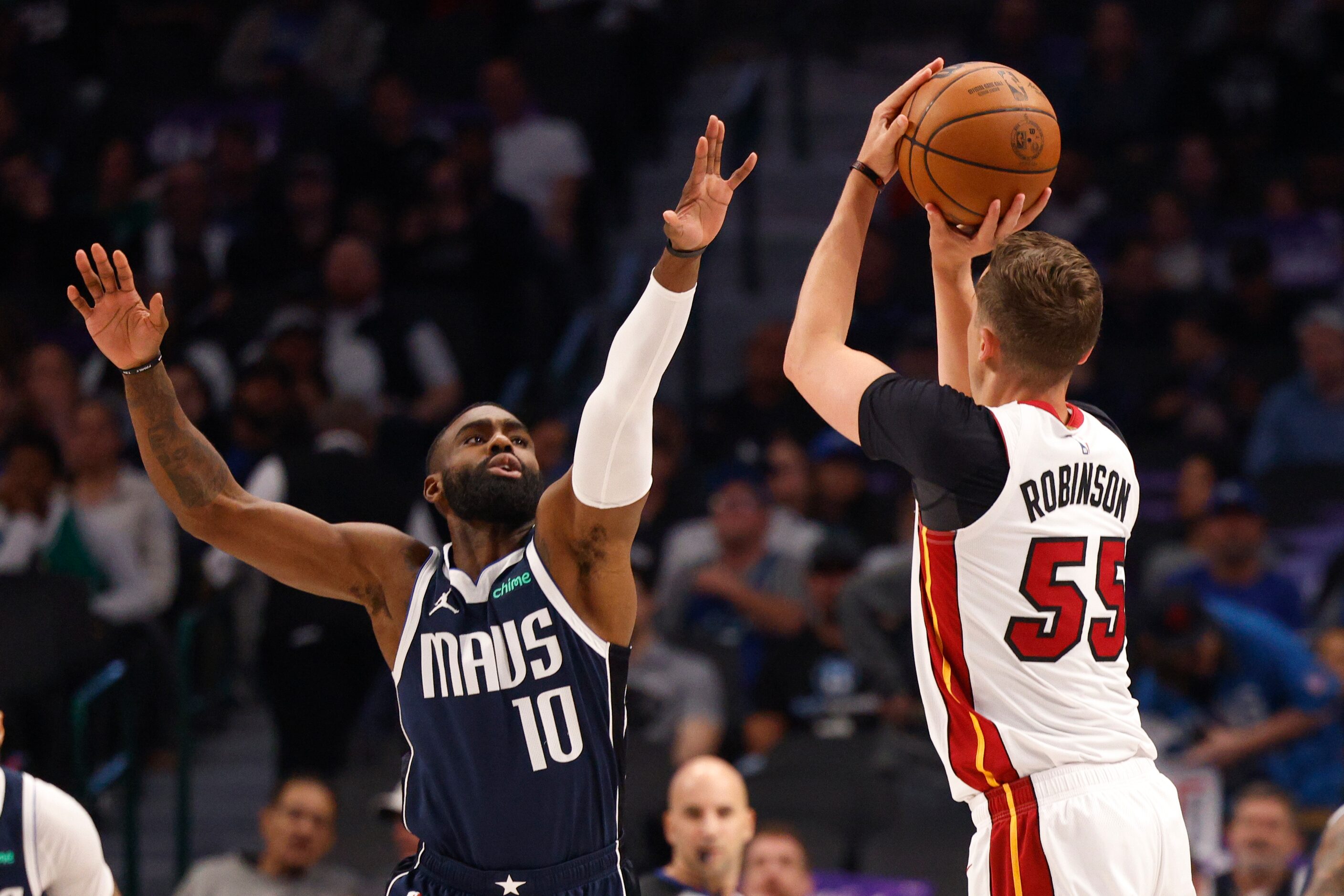 Dallas Mavericks forward Tim Hardaway Jr. (10) defends a three-point attempt from Miami Heat...