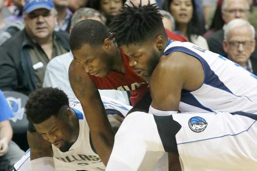 Miami Heat guard Dion Waiters, center, chases the loose ball against Dallas Mavericks guard...