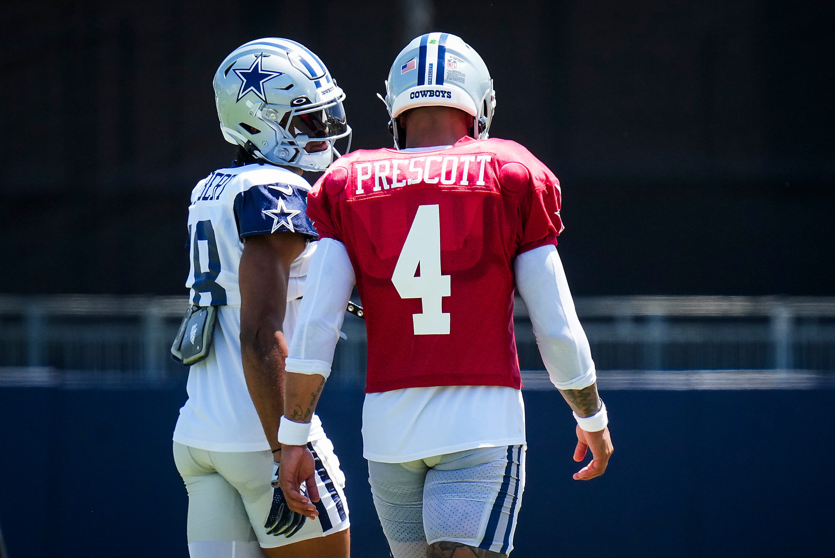 Dallas Cowboys wide receiver Jalen Tolbert (18) talks with quarterback Dak Prescott (4)...