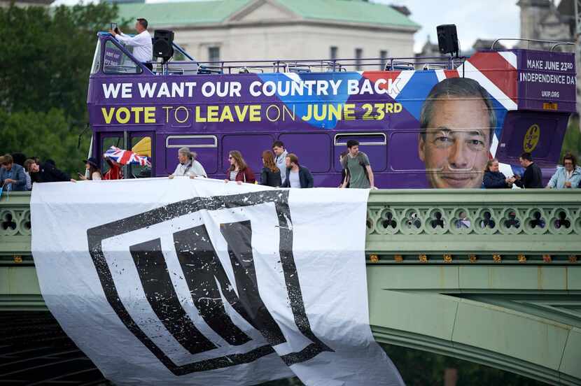 Campaigners to remain in the European Union unfurl a banner on Westminster Bridge as a bus...
