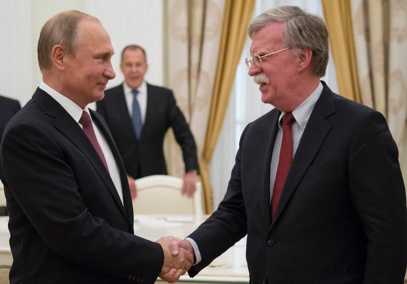 Russian President Vladimir Putin (left) shakes hands with U.S. National Security adviser...