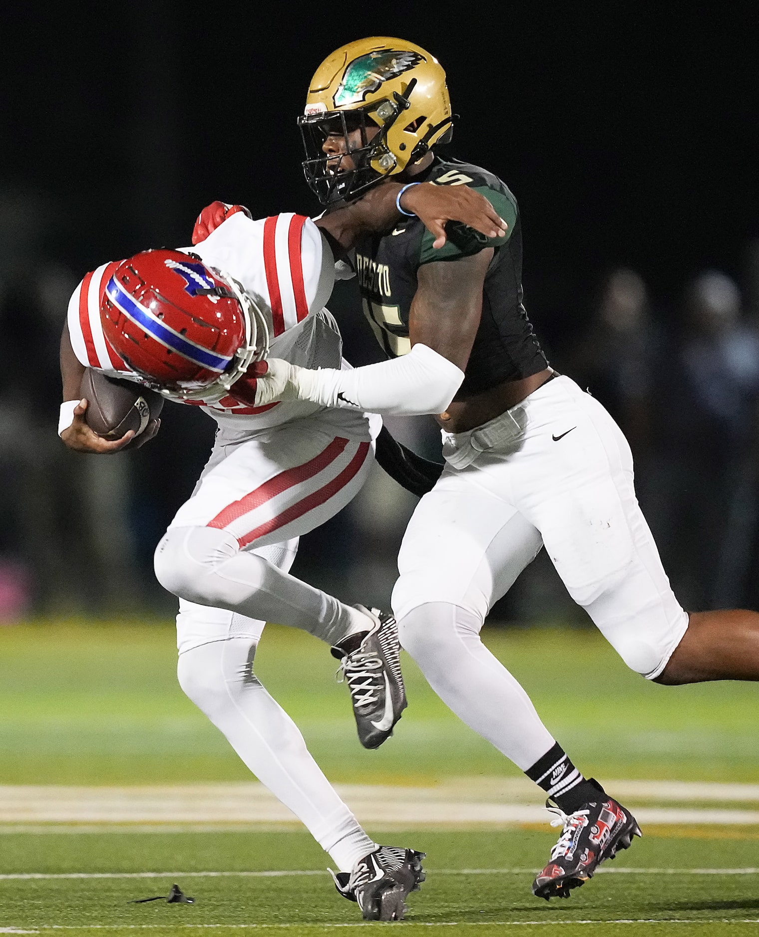 Duncanville quarterback Keelon Russell (12) is brought down by DeSoto defensive lineman...