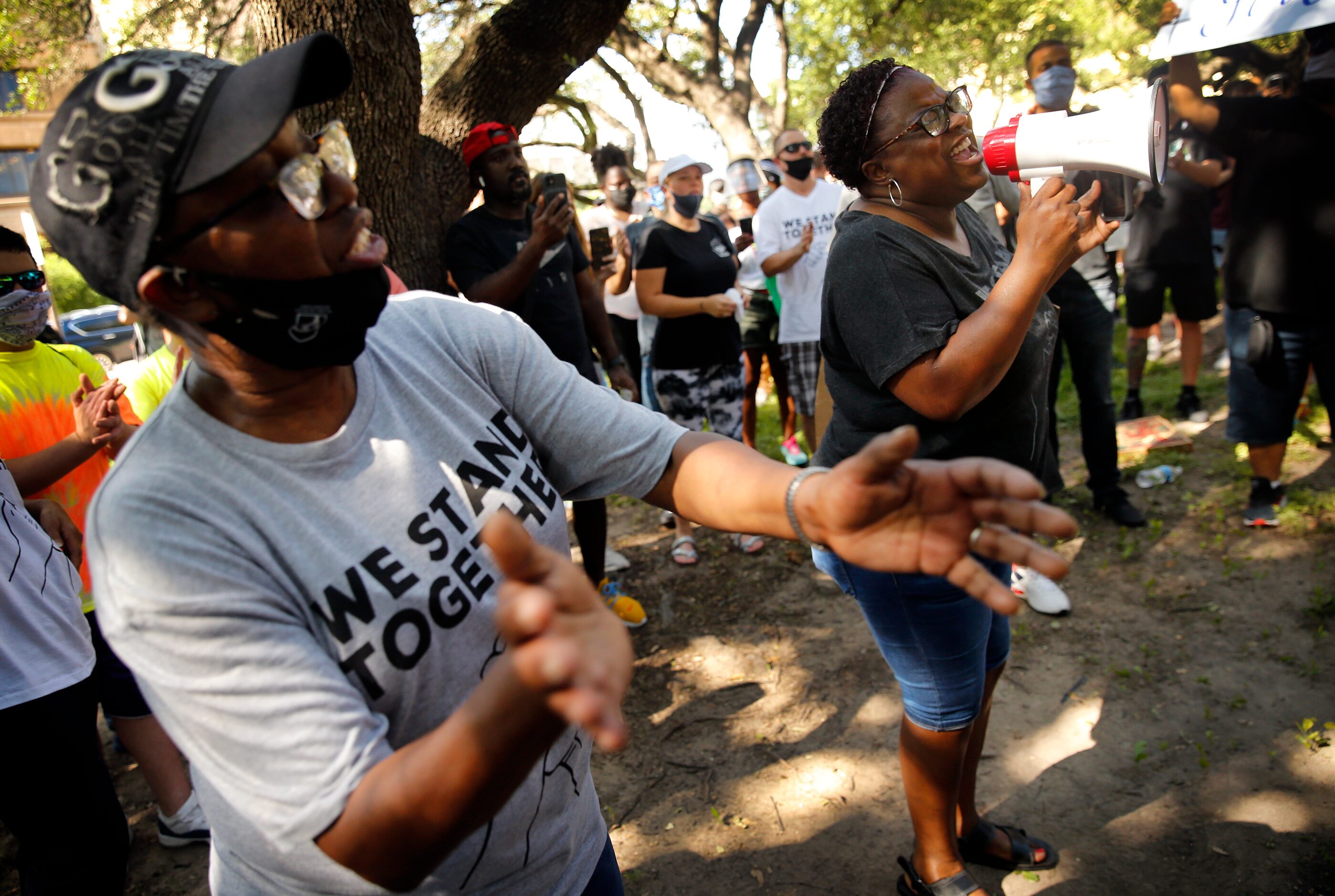 Panda Ross (right) and Shanna Wilson lead the Community of Faith Gathering in song as they...