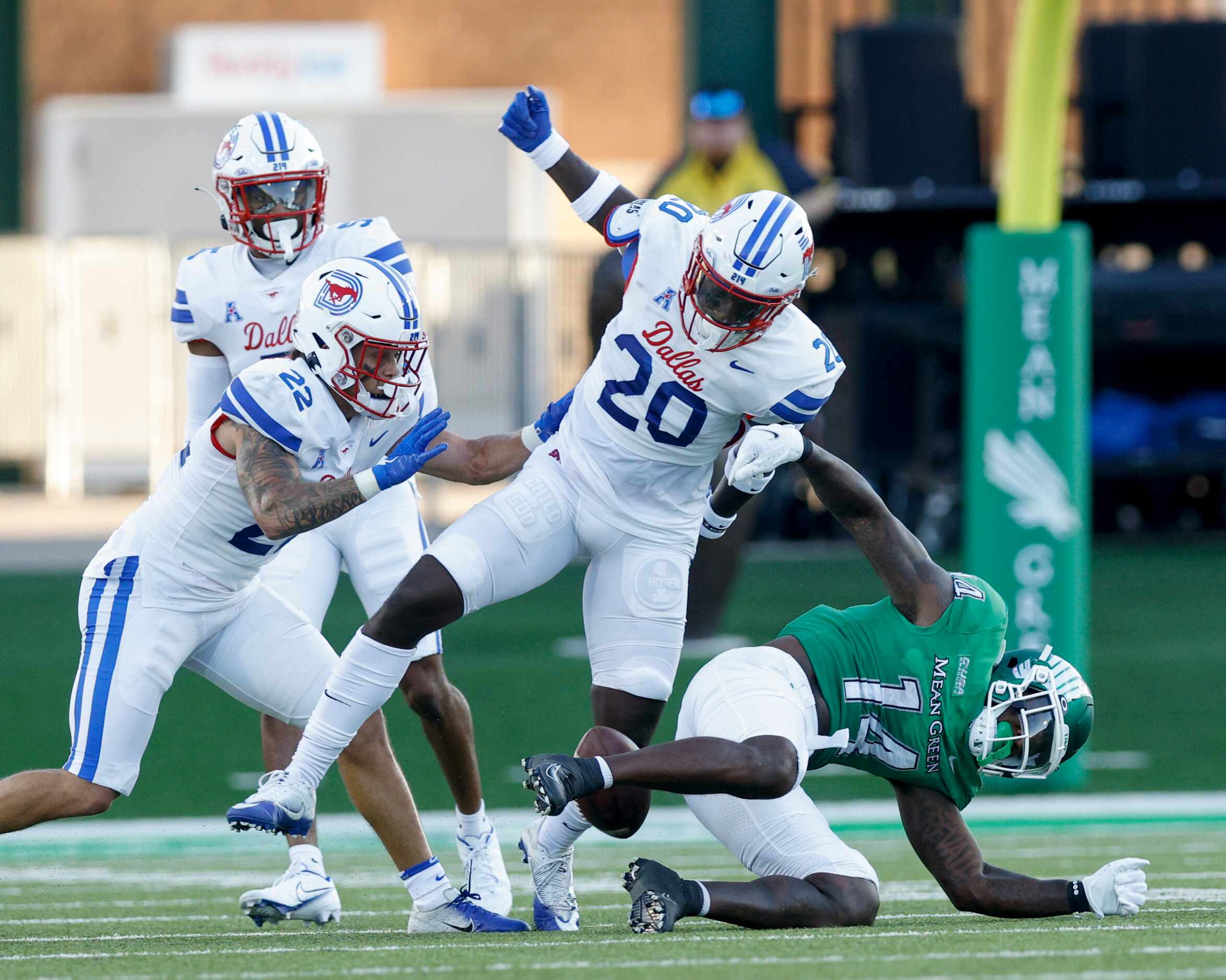 SMU safety Chris Adimora (20) forces a fumble from UNT wide receiver Roderic Burns (14)...