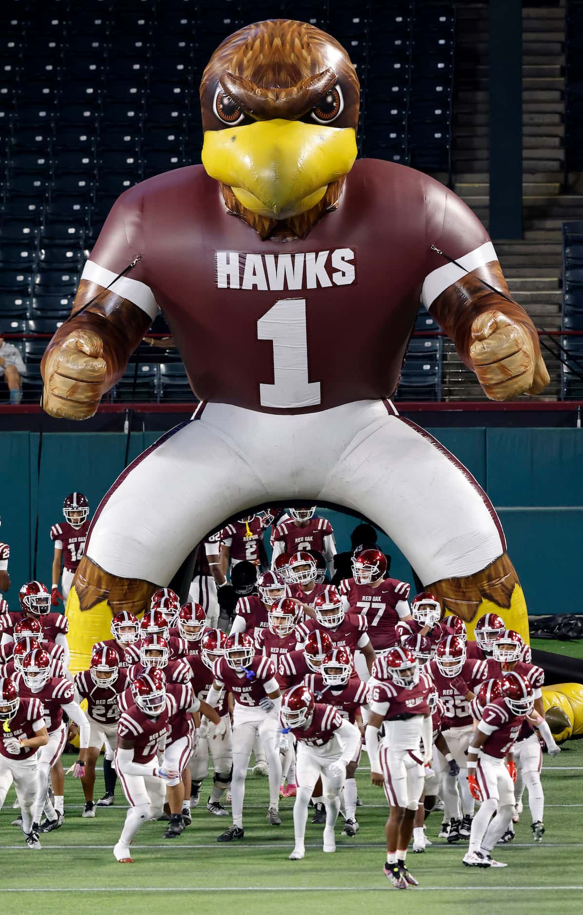 The Red Oak Hawks football team races onto the field to face Aledo in their Class 5A...