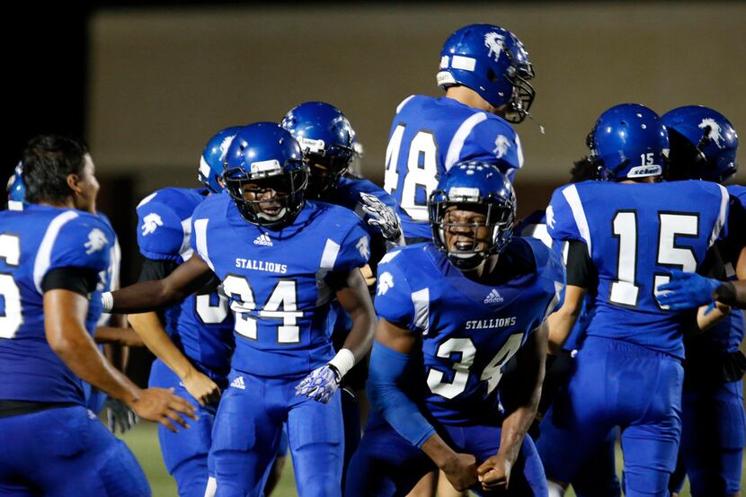 North Mesquite football team members, including Daniel Dunn (24) and Byron Turner (34)...