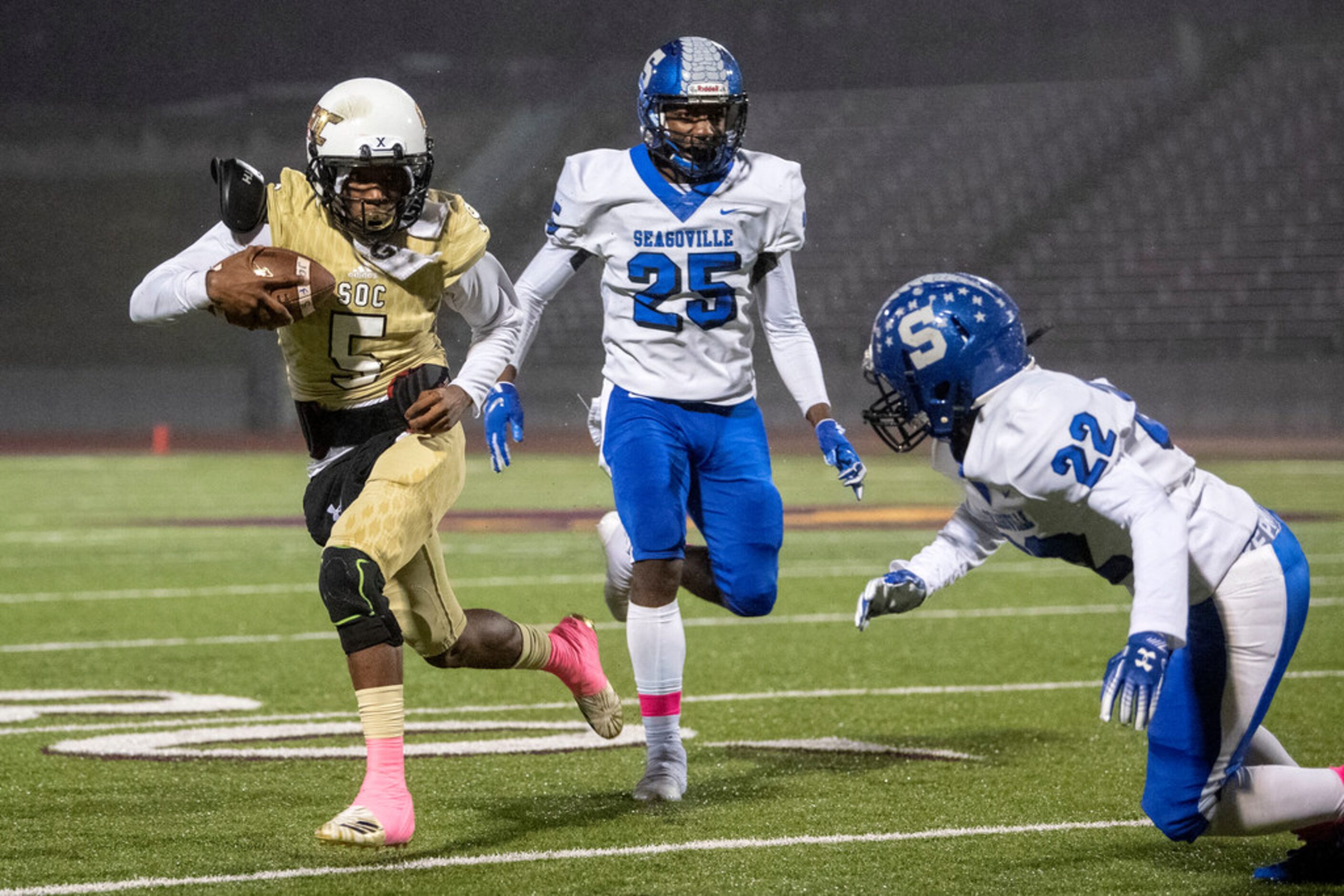 South Oak Cliff senior quarterback Donajz Dunn (5) tries to avoid the tackle of Seagoville...