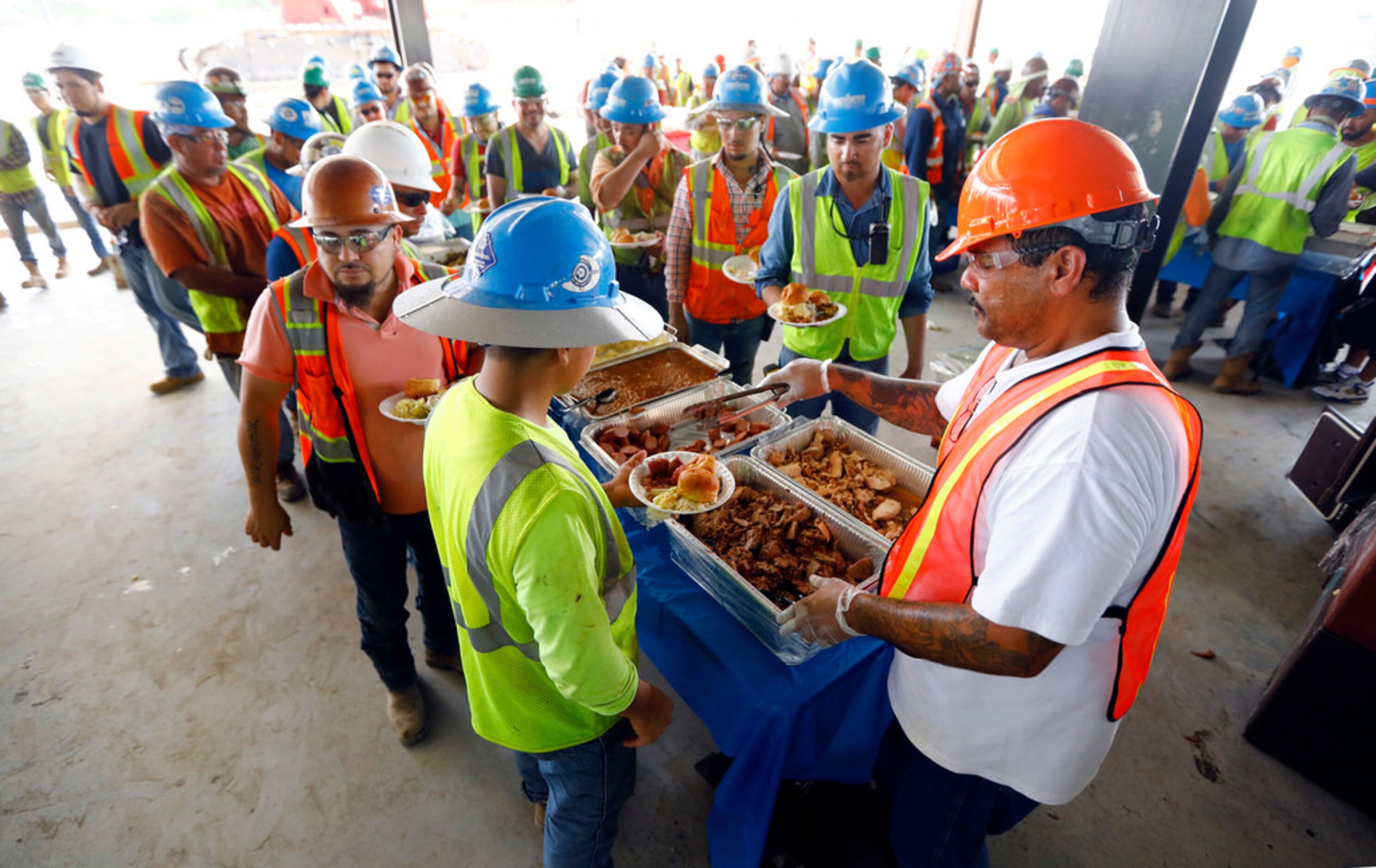 Hundreds of construction workers lined up for a barbecue luncheon provided by Manhattan...