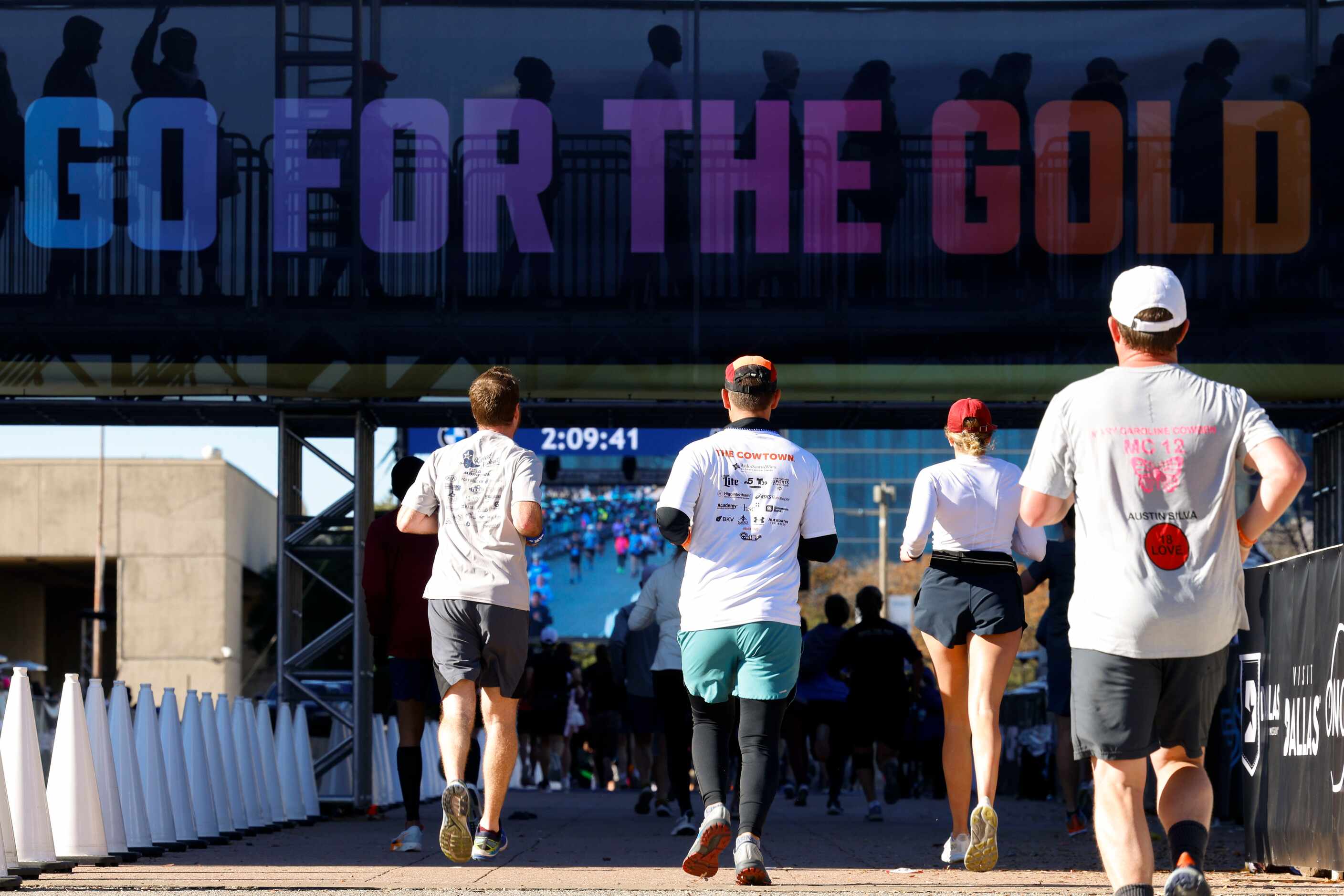 Half marathon runners run along Marilla St. close by the finish line during 2023 BMW Dallas...
