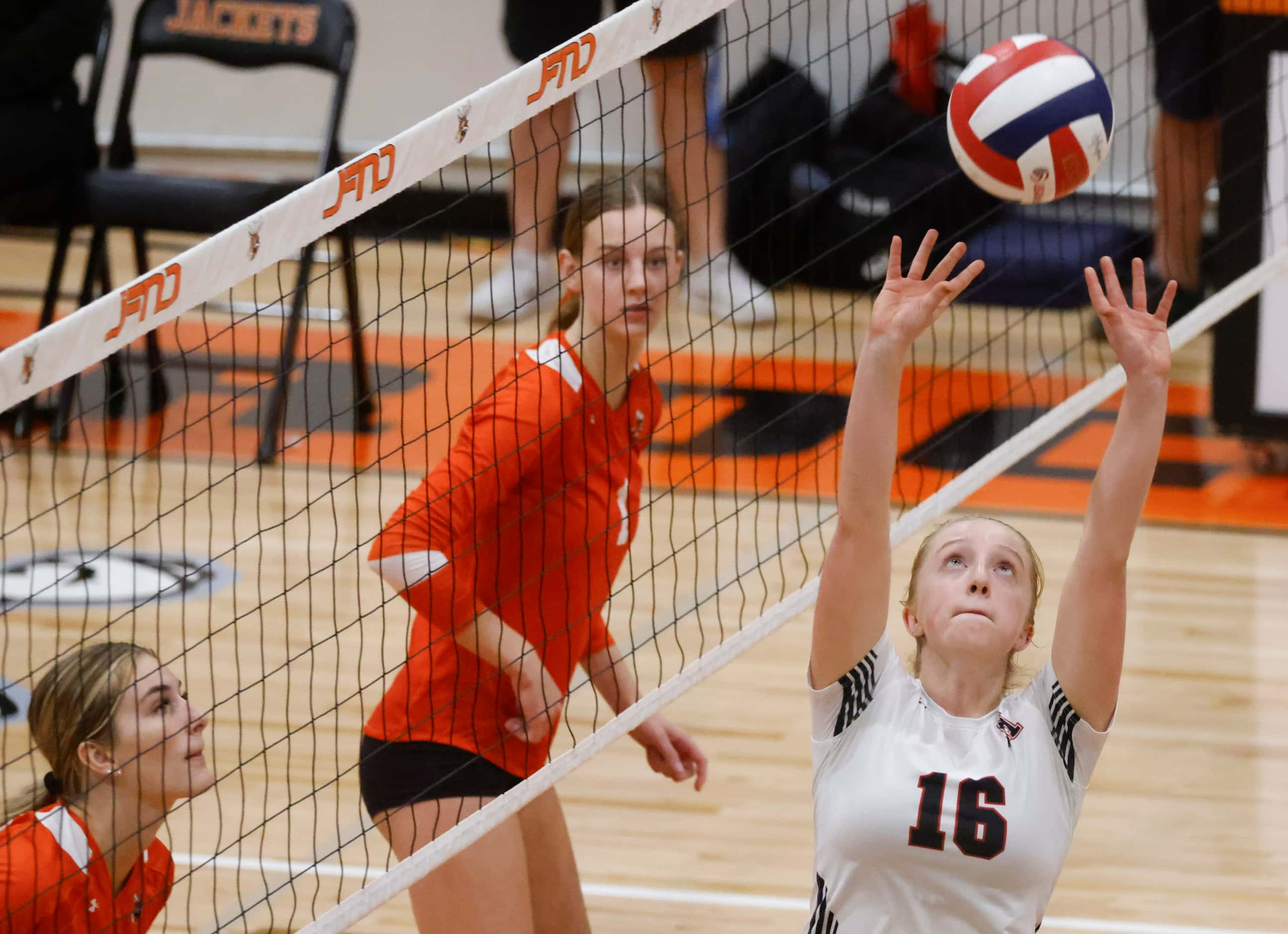 Rockwall Heath’s Logan Younger (16) sets the ball as Rockwall High’s Halle Jameson (back)...