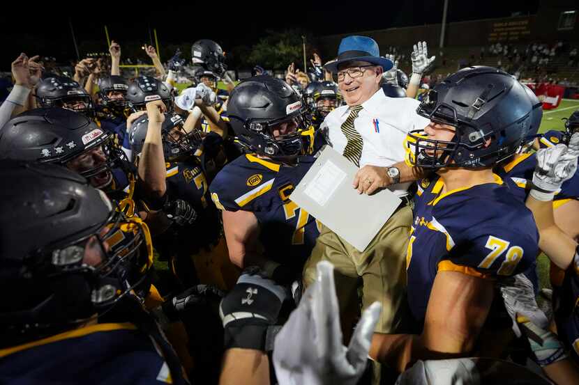 Highland Park head coach Randy Allen is lifted up by his players after a victory over Lake...