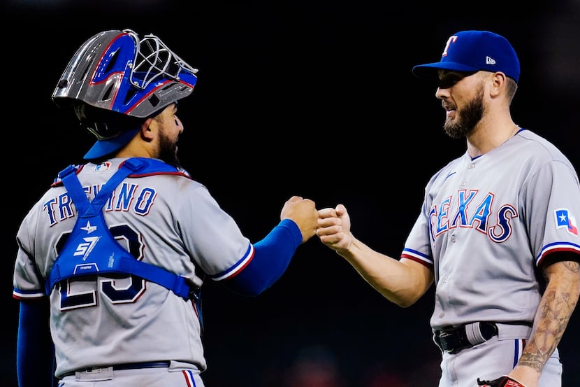 Texas Rangers relief pitcher Joe Barlow, right, gets a fist bump from catcher Jose Trevino...