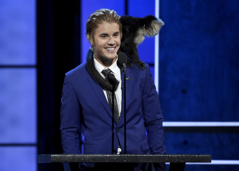 A monkey rests on Justin Bieber's shoulder as he speaks at the Comedy Central Roast of...