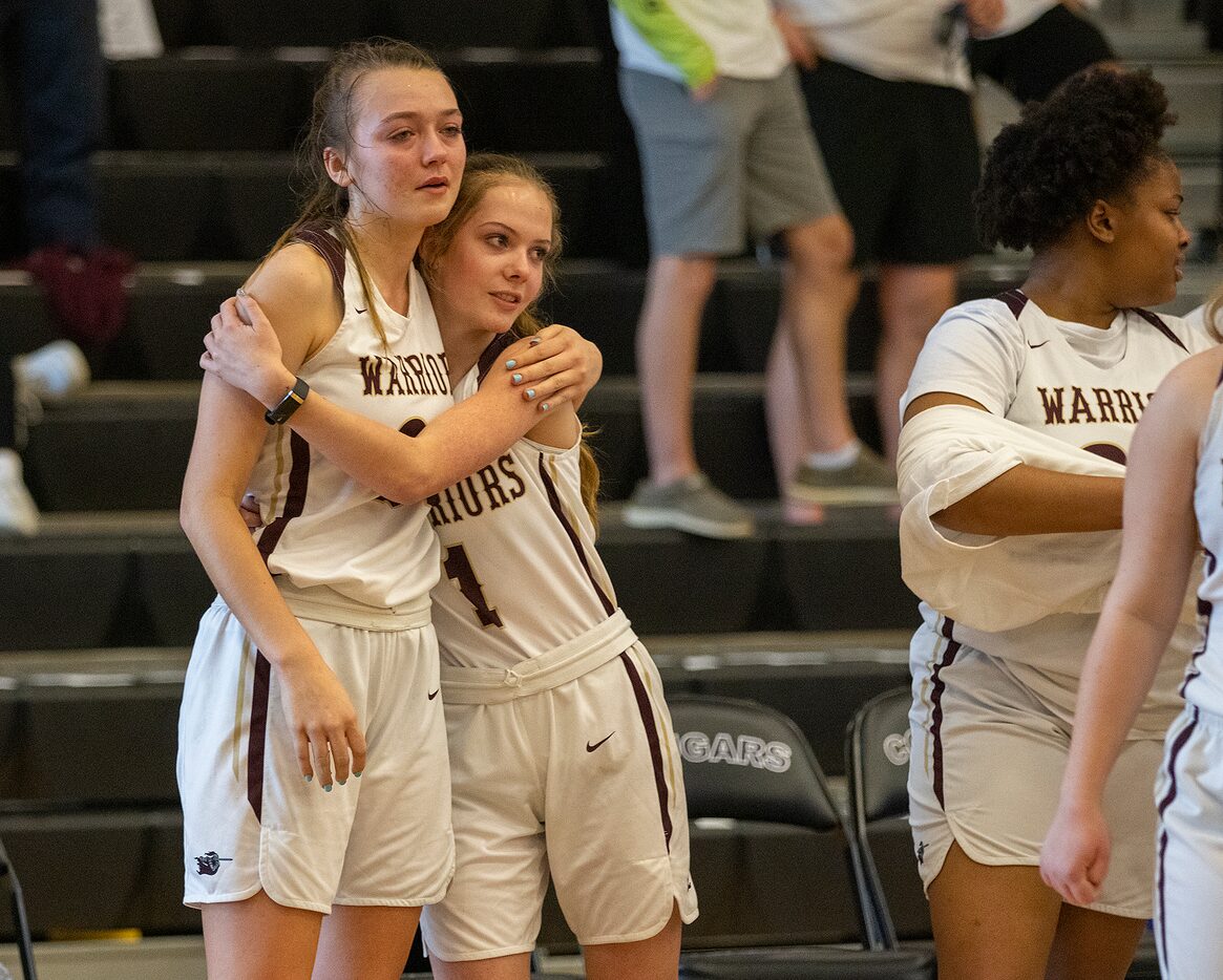 McKinney Cornerstone's Carrigan Moore (1) consoles teammate Taylor Garrett (21) following a...