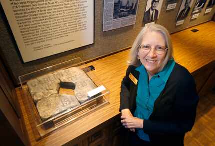 University archivist Betty Shankle poses next to a broken marble marker with the inscription...