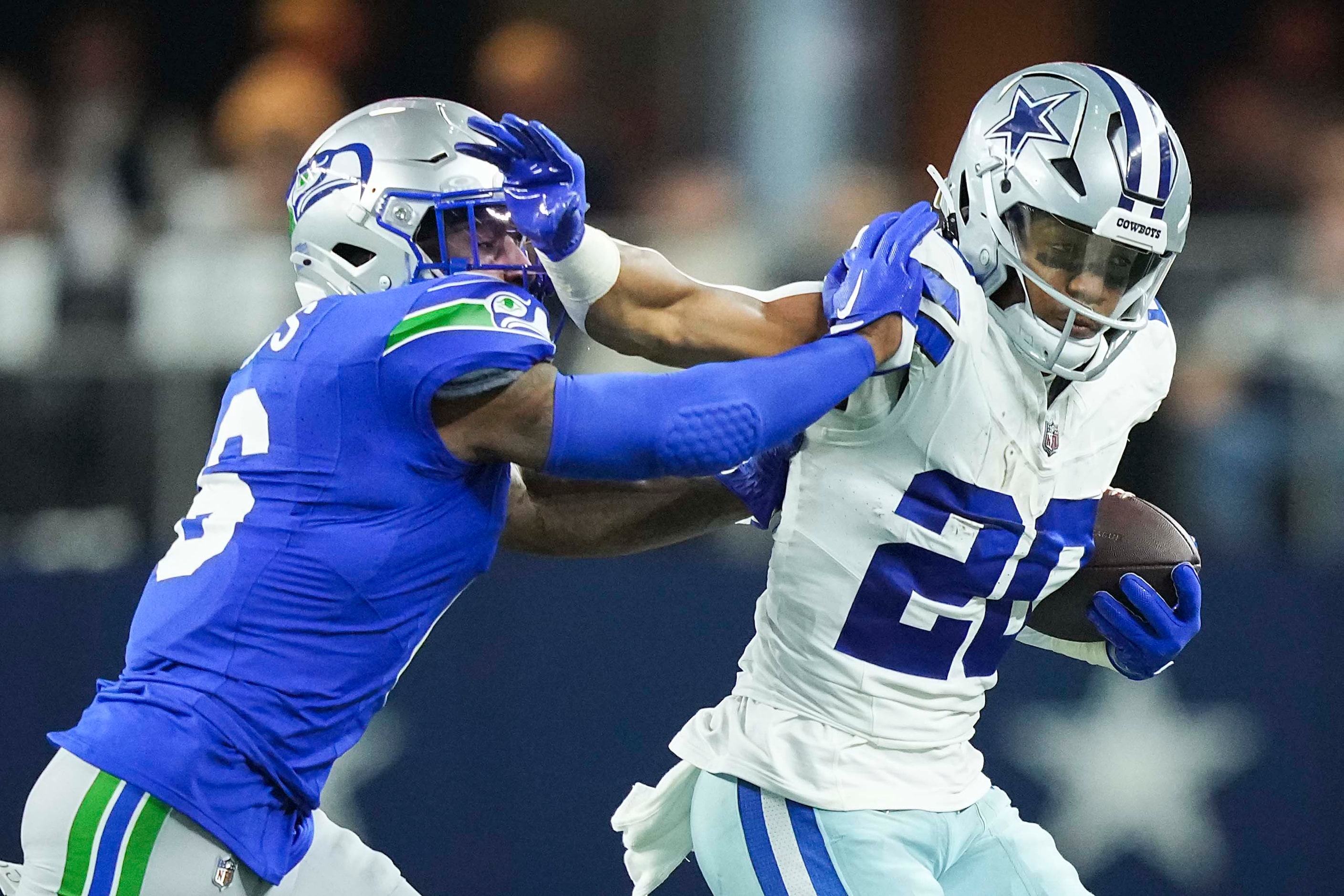 Dallas Cowboys running back Tony Pollard (20) pushes past Seattle Seahawks safety Quandre...