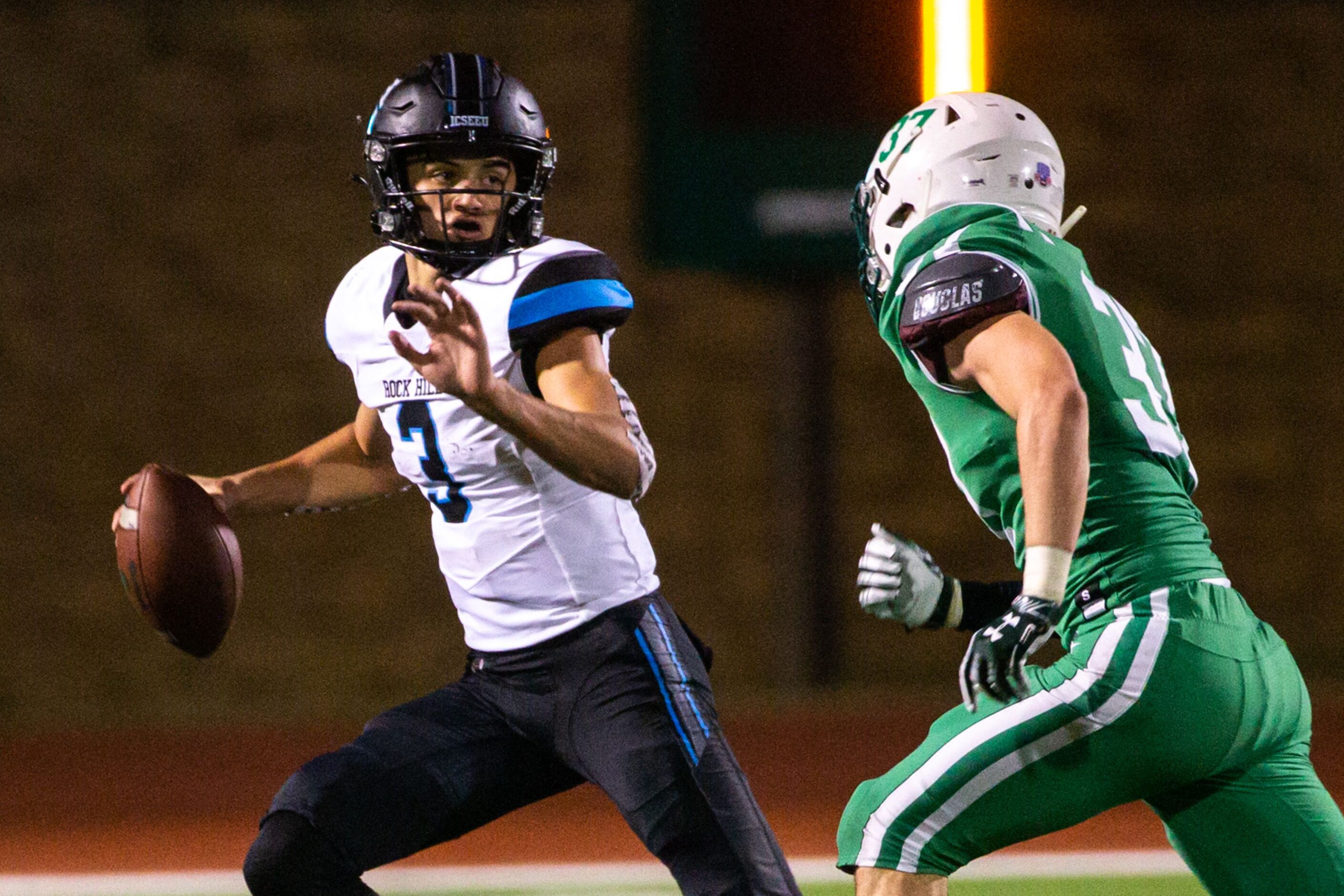 Rock Hill quarterback Brenner Cox (4) looks to evade a block attempt by Lake Dallas...