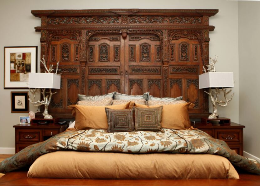 The headboard in the master bedroom made from a gate at a Tibetan temple in the home of...