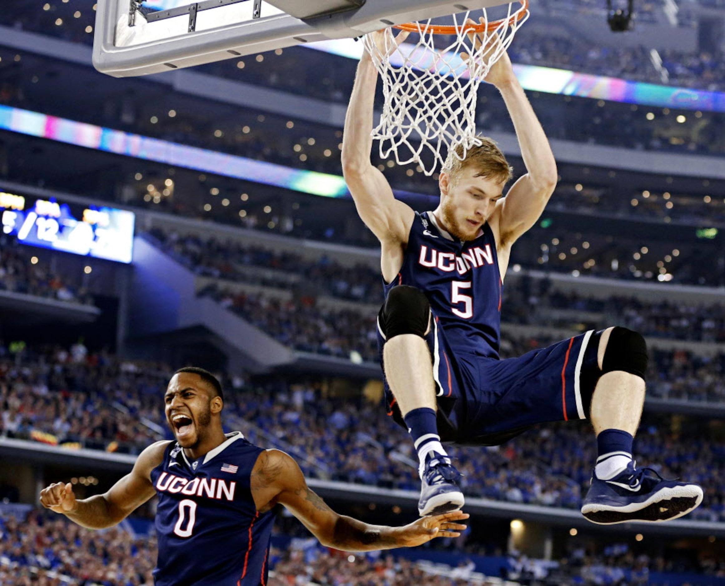 Connecticut Huskies forward Phillip Nolan (0) reacts to a dunk by Niels Giffey during the...