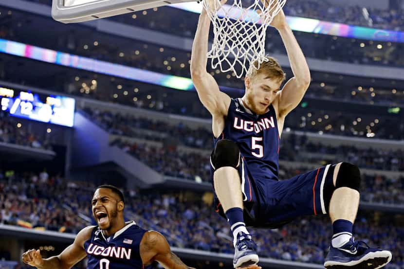 Connecticut Huskies forward Phillip Nolan (0) reacts to a dunk by Niels Giffey during the...