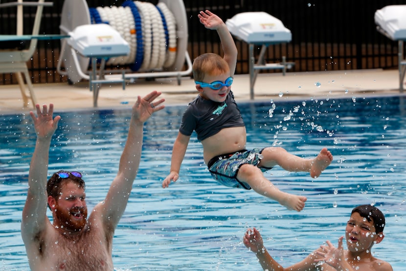 Zeke Koelpin, 3, mimics the form of a bull rider as he flies through the air after being...