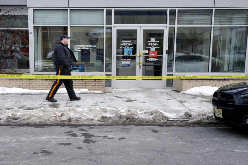 Police officers stand guard outside the closed post office in Wood-Ridge, N.J., Friday, Jan....