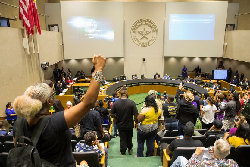 Protesters raised their fists and yelled "no justice, no peace" during a City Council...