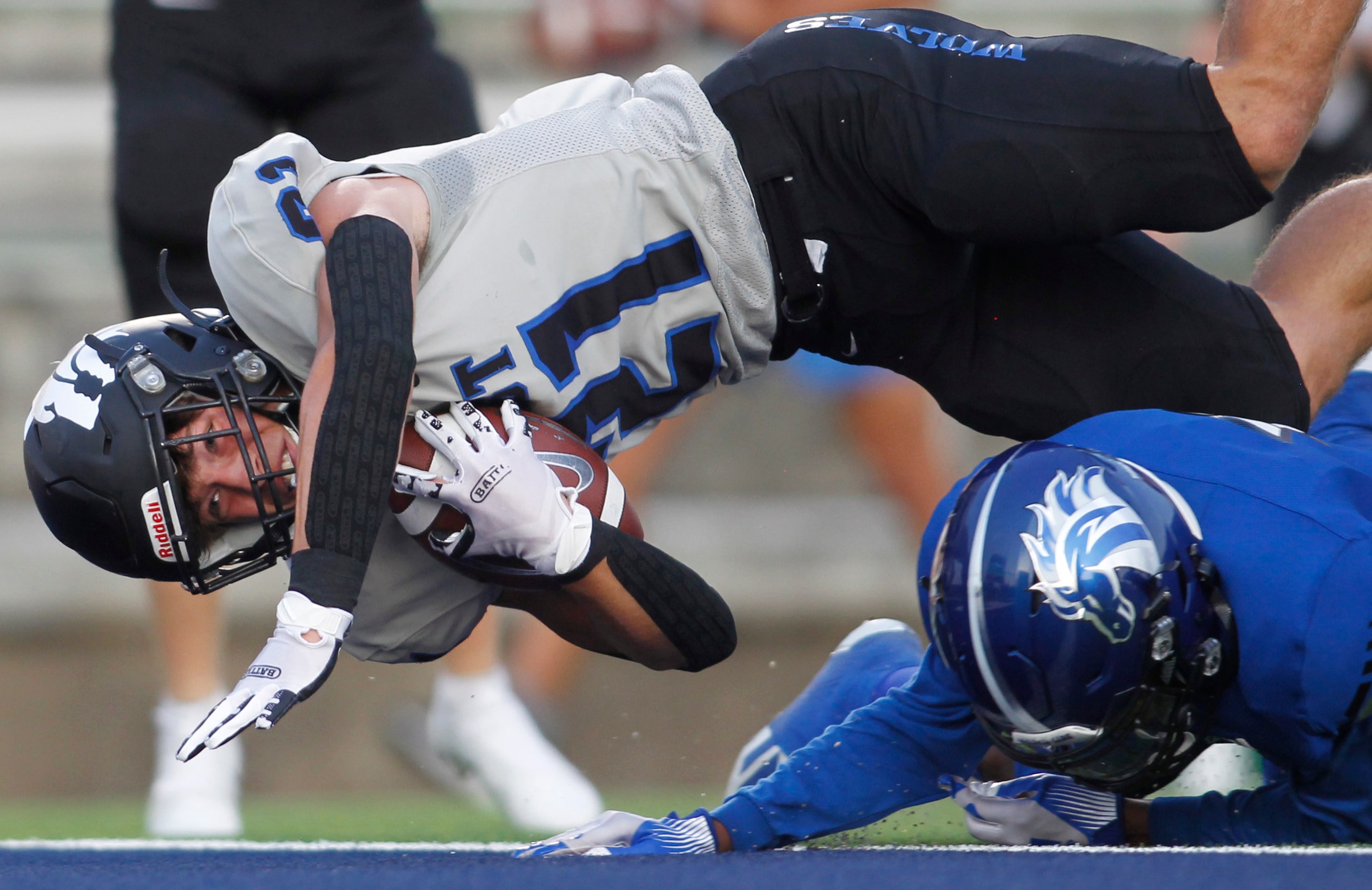 Plano West running back Dermot White (21) dives over North Mesquite's Da'lan Hicks (3) for a...