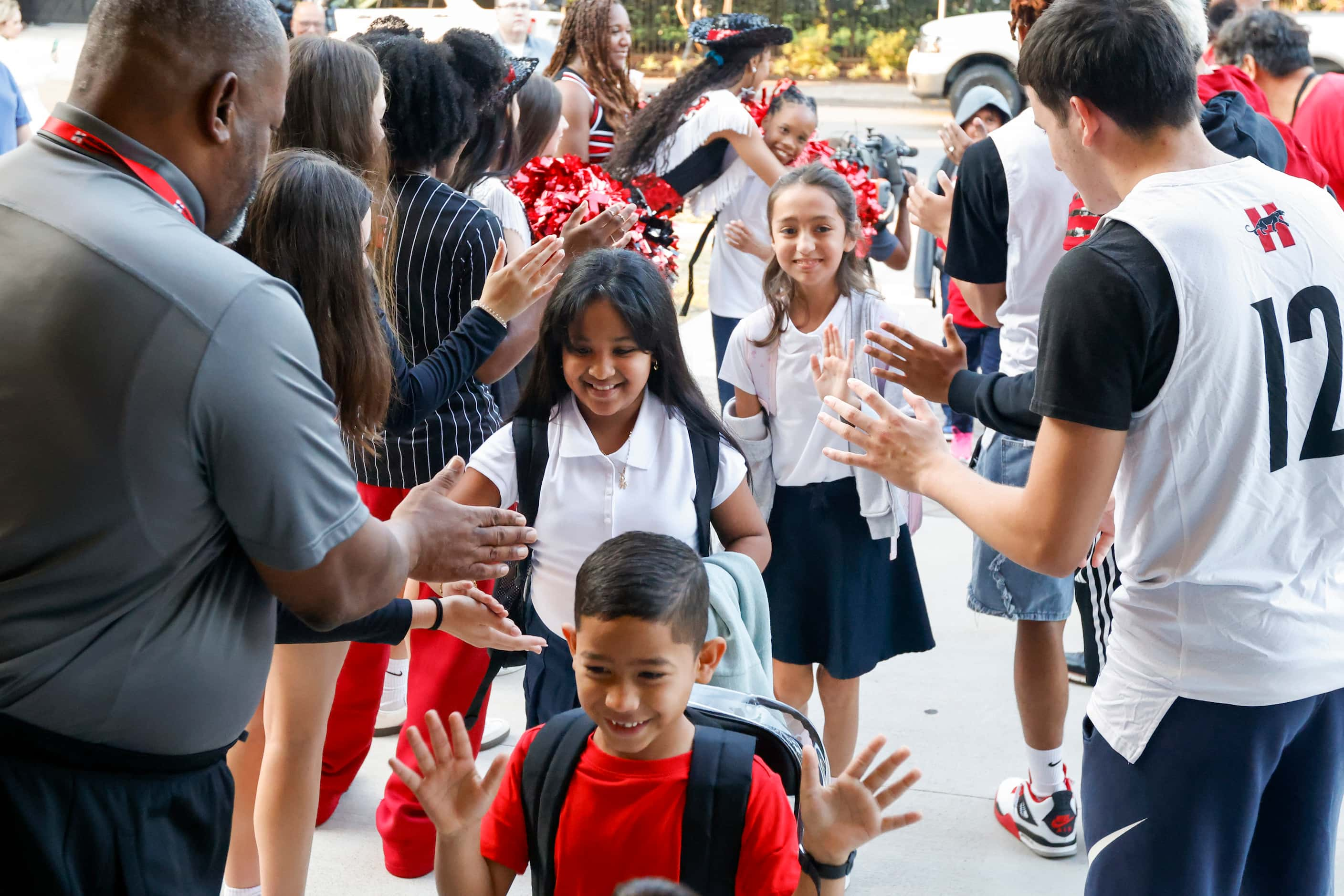 Students at John J. Pershing Elementary School high-five Hillcrest High School...