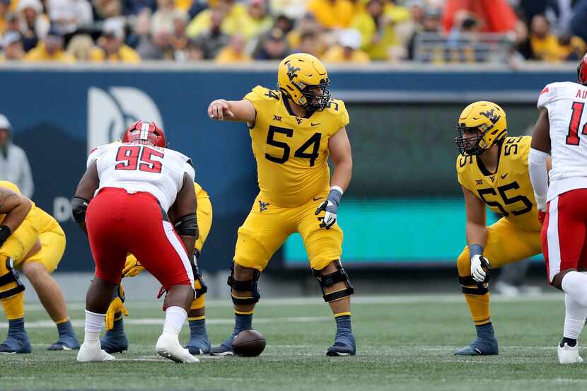 West Virginia's Zach Frazier (54) calls signals at the line against Texas Tech during an...
