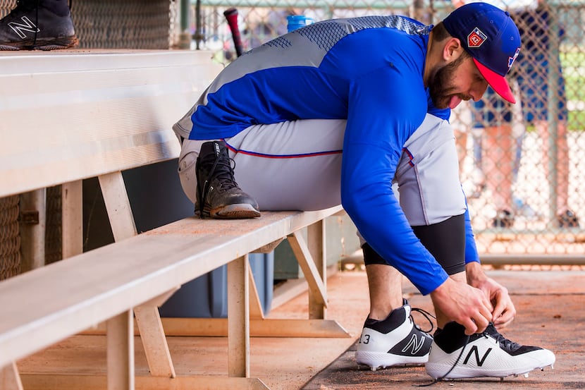 Texas Rangers infielder Joey Gallo laces up a brand new pair of cleats during a spring...