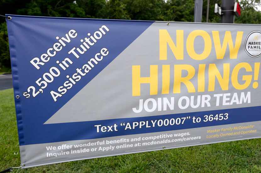 A now hiring sign boasts tuition assistance enticement to attract potential workers at this...