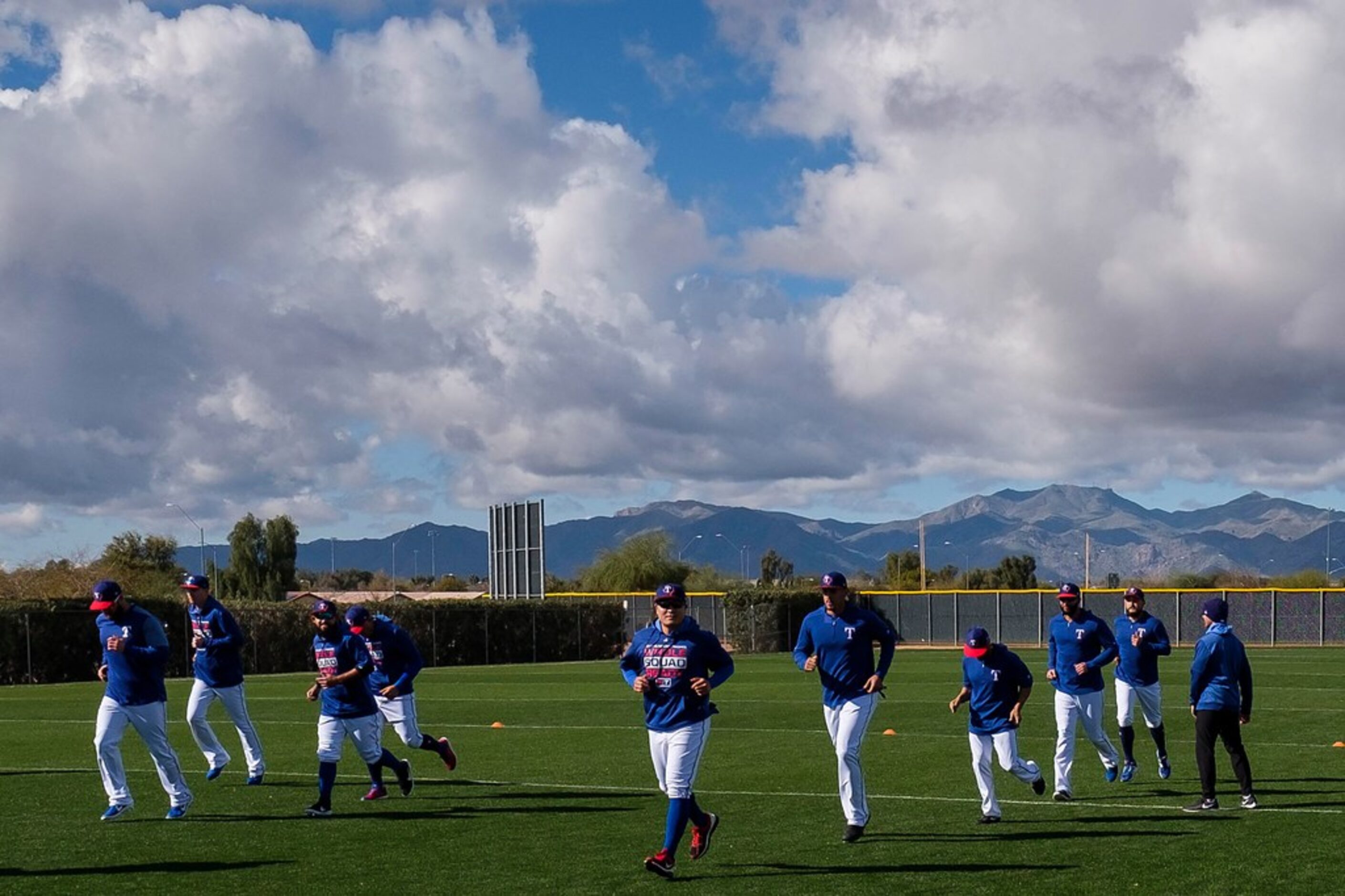 Texas Rangers position players run on a conditioning field during the first full squad...