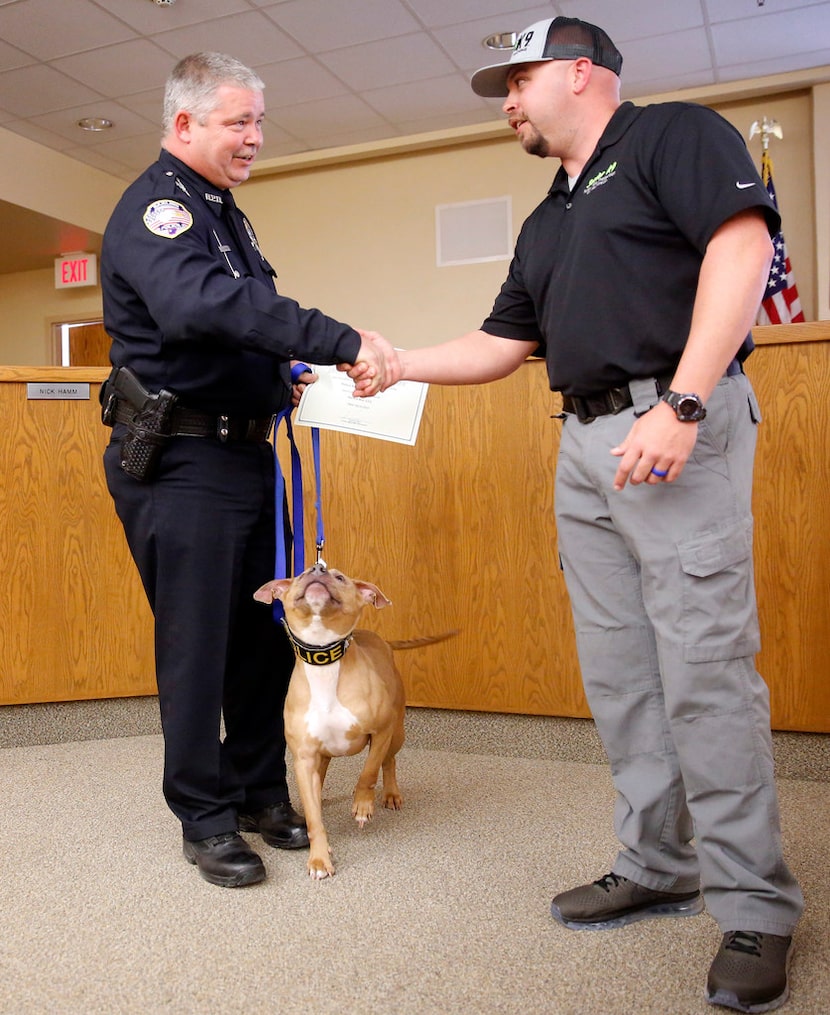 City of Barling (Ark.) police Officer Don Rowe (left) is congratulated by Sector K9 operator...