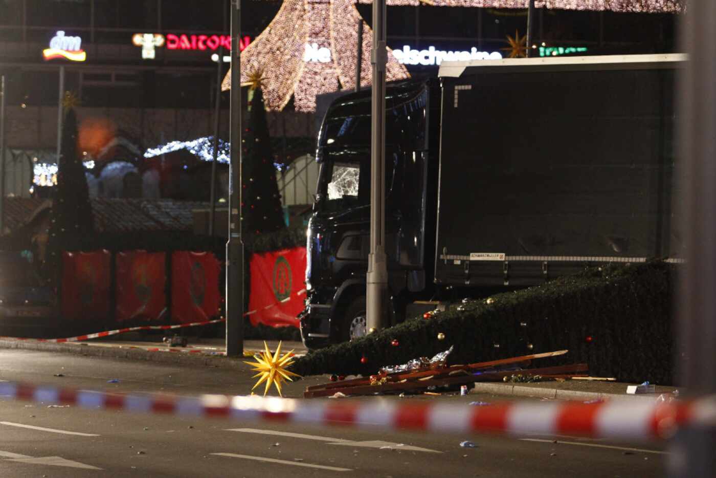 A crushed Christmas tree lays on the ground beside debris after a lorry truck was ploughed...