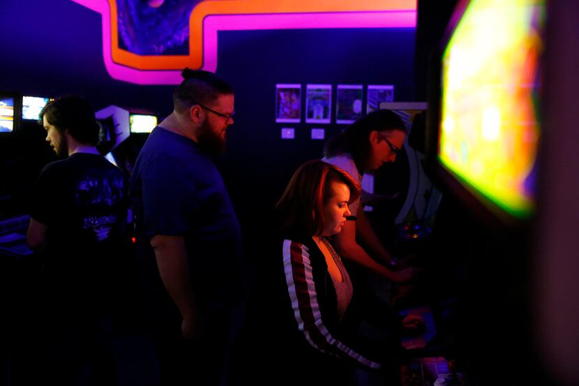 Jess Alvarez (center), of Irving, Texas, plays Ms. Pac-Mac during the soft opening of the...