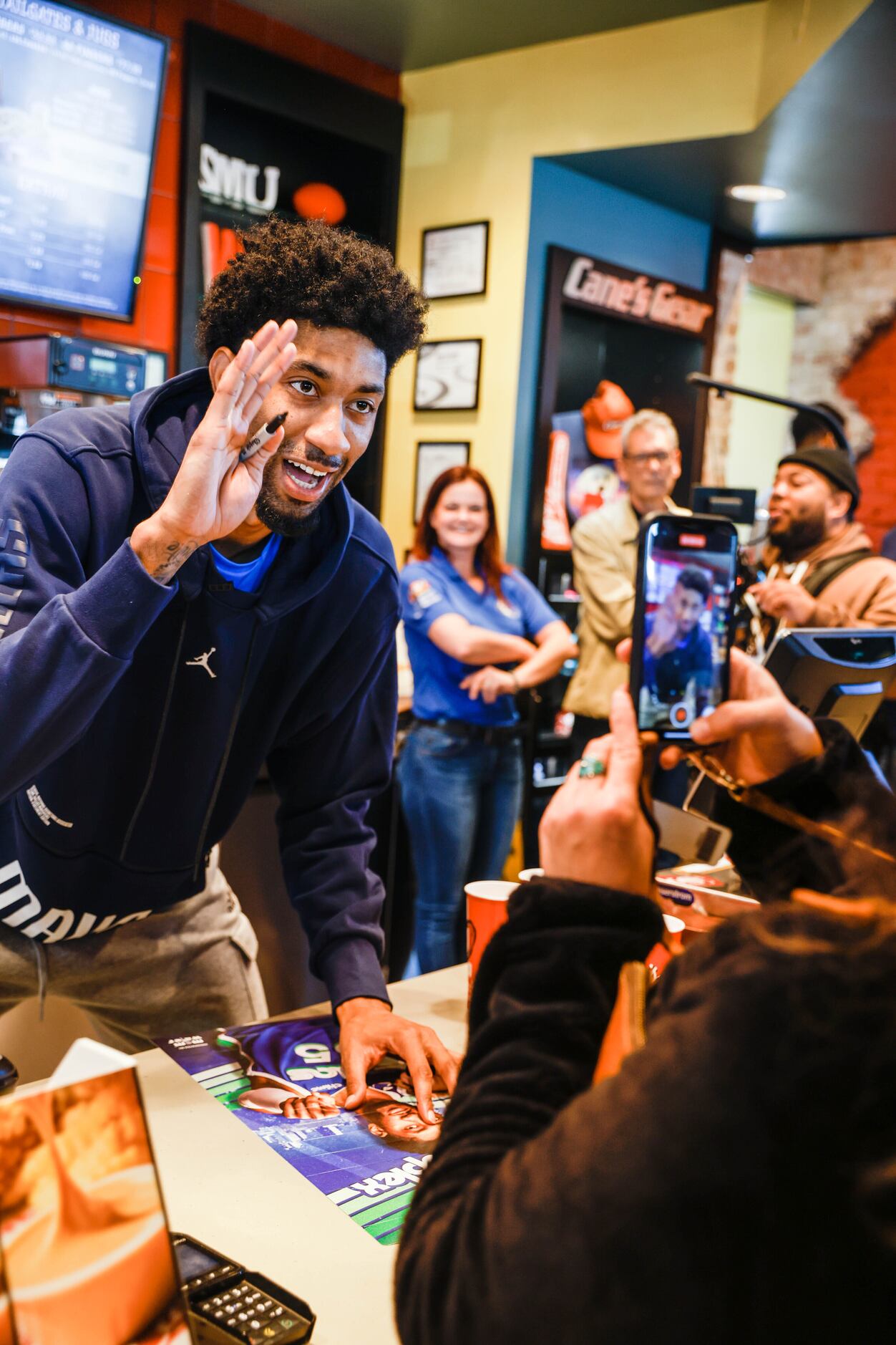 Mavericks player Christian Wood gives an autograph to a costumer at the Raising Cane’s in...