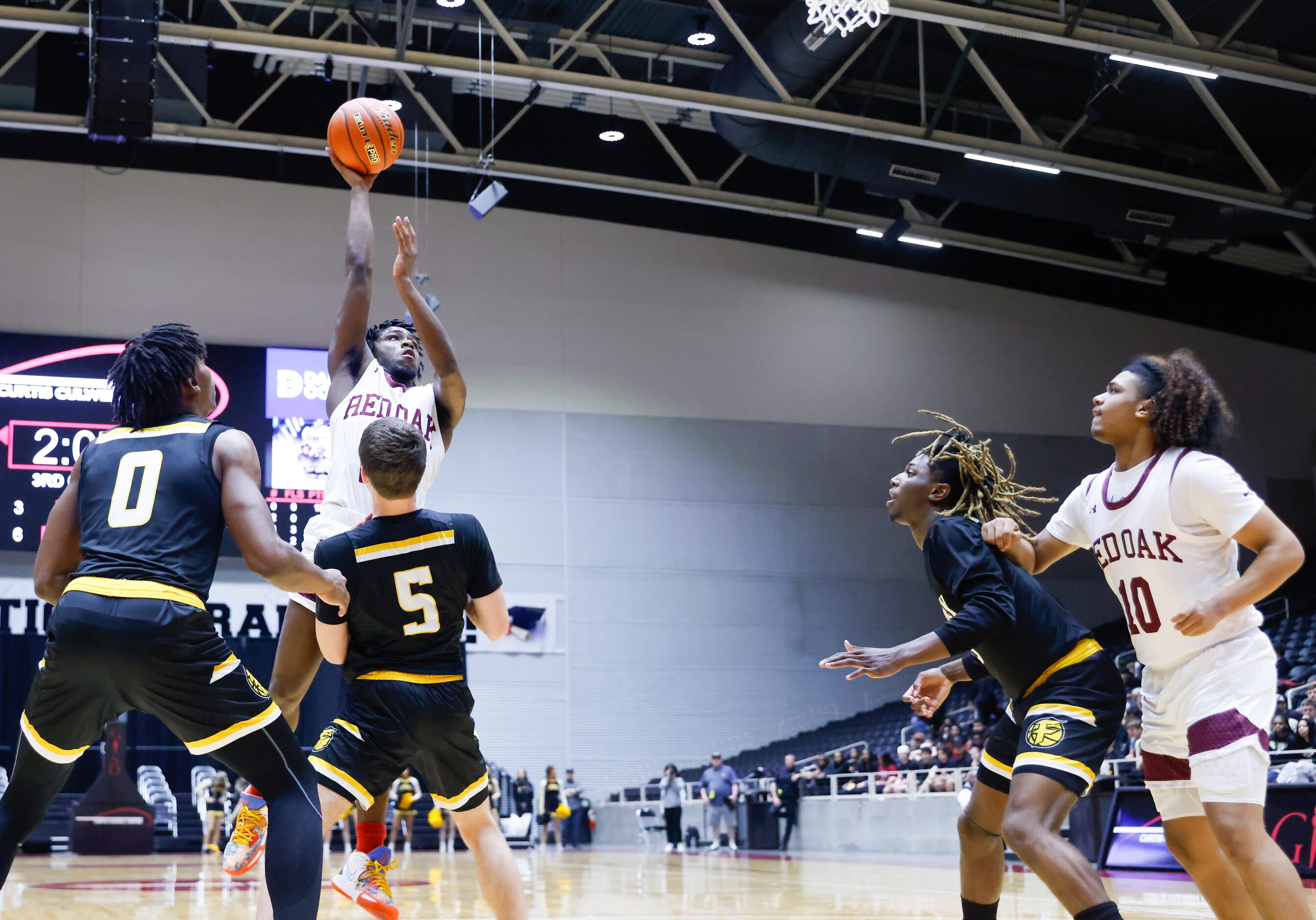 Red Oak junior guard Kamal Brooks (24, center) attempts a two-point shot on the net despite...