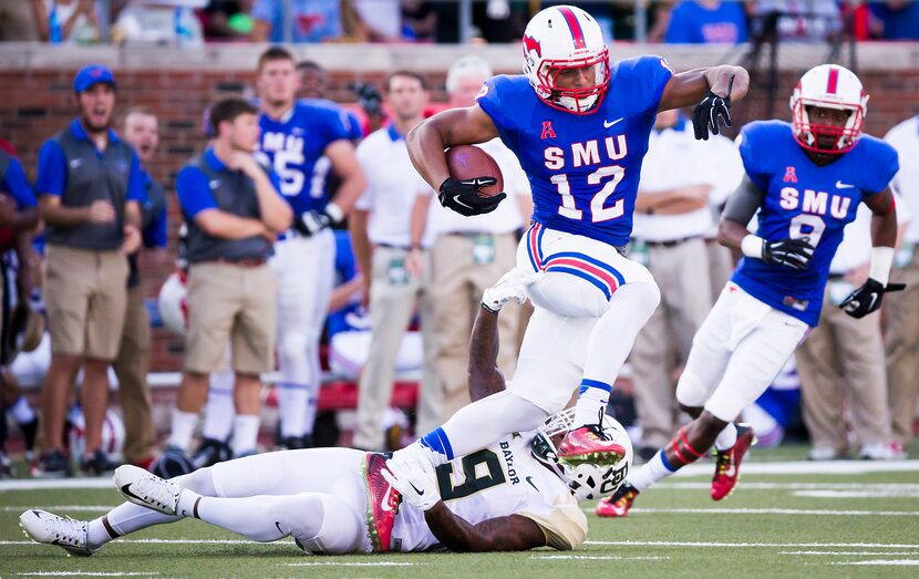 SMU wide receiver Xavier Castille (12) is tripped up by Baylor cornerback Ryan Reid (9)...