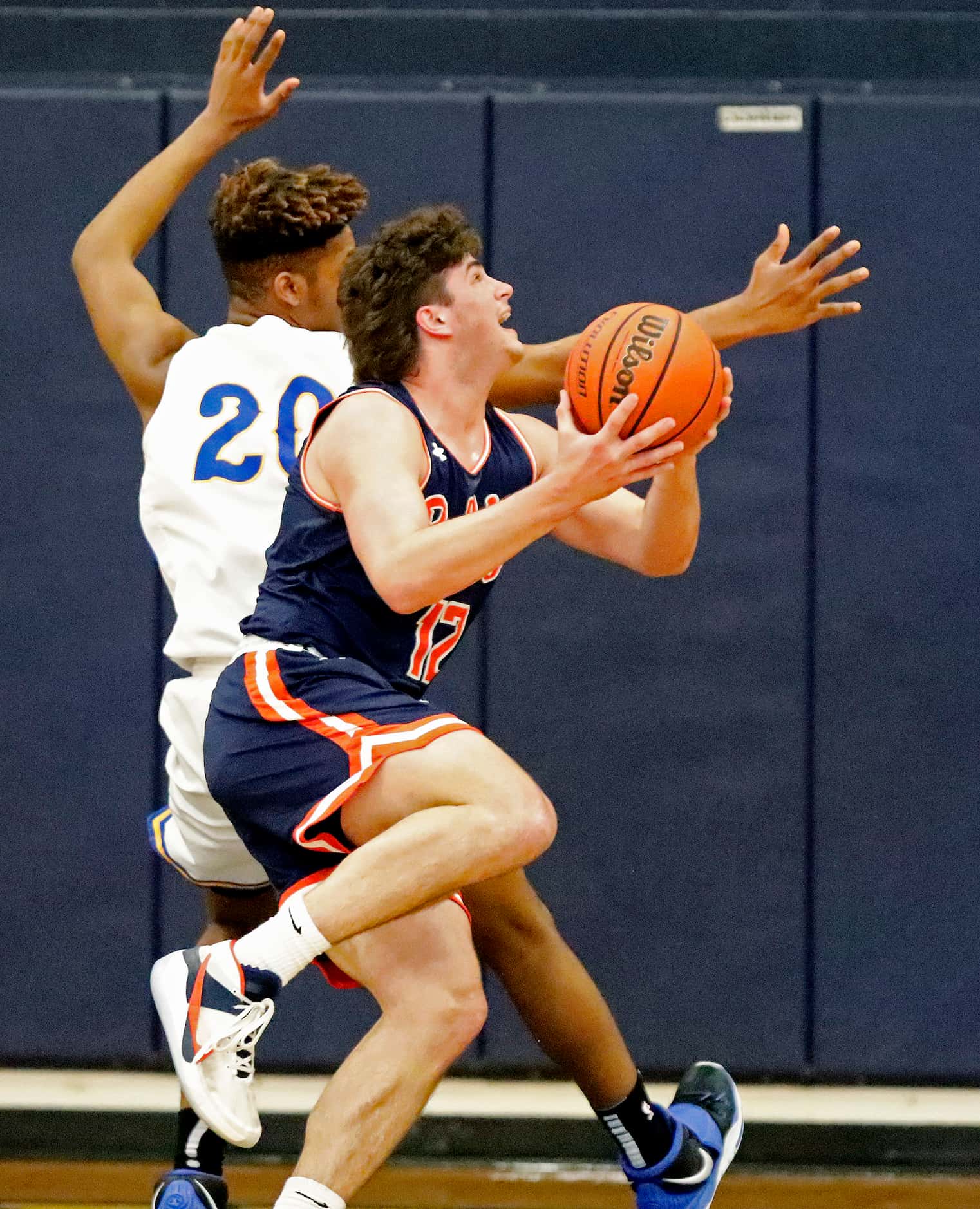 McKinney North High School post Dylan Frazier (12) puts up a shot and draws a foul while...