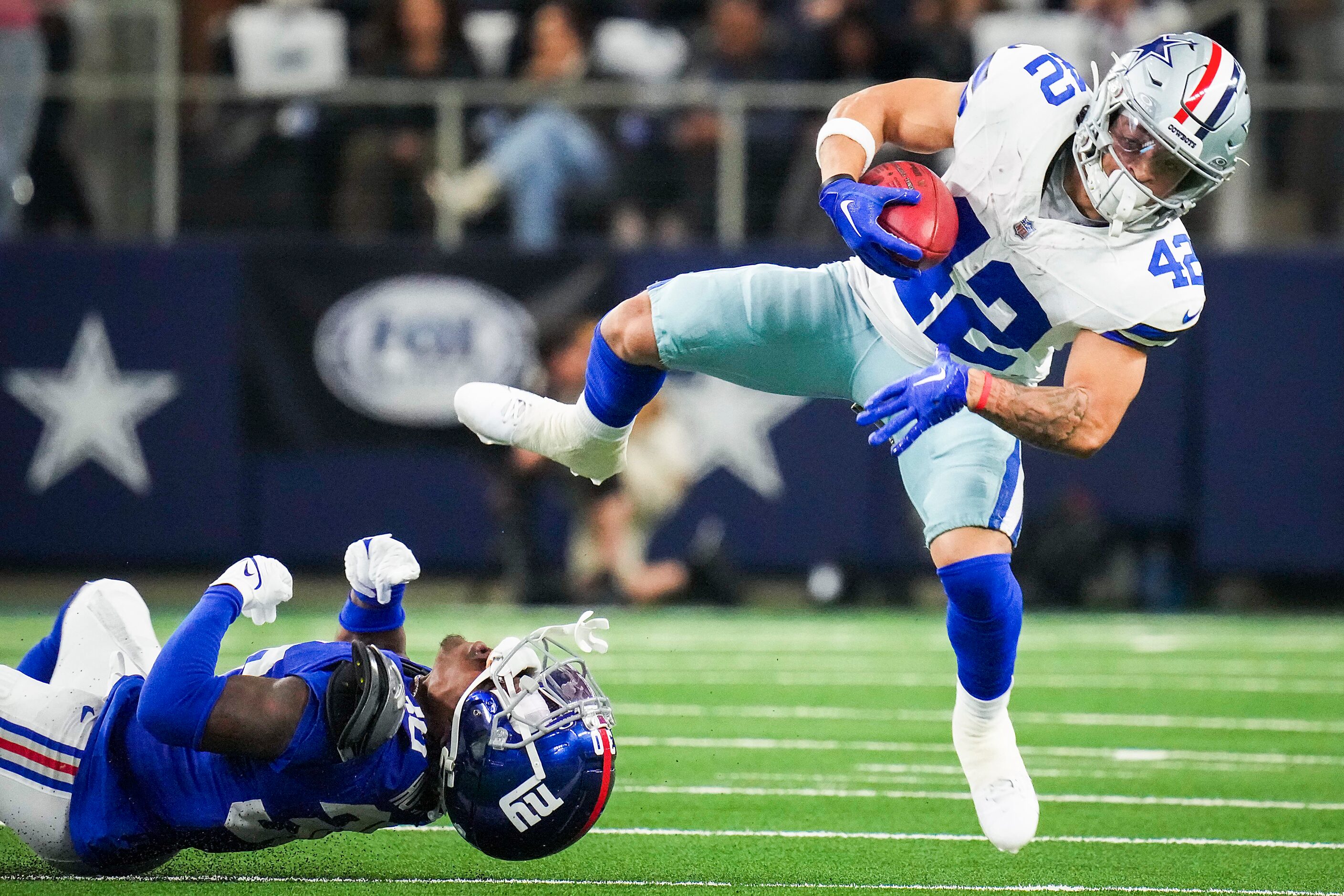 Dallas Cowboys running back Deuce Vaughn (42) is tripped up by New York Giants cornerback...