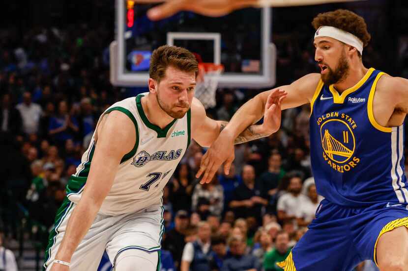 Dallas Mavericks guard Luka Doncic (77) tries to go around Golden State Warriors guard Klay...