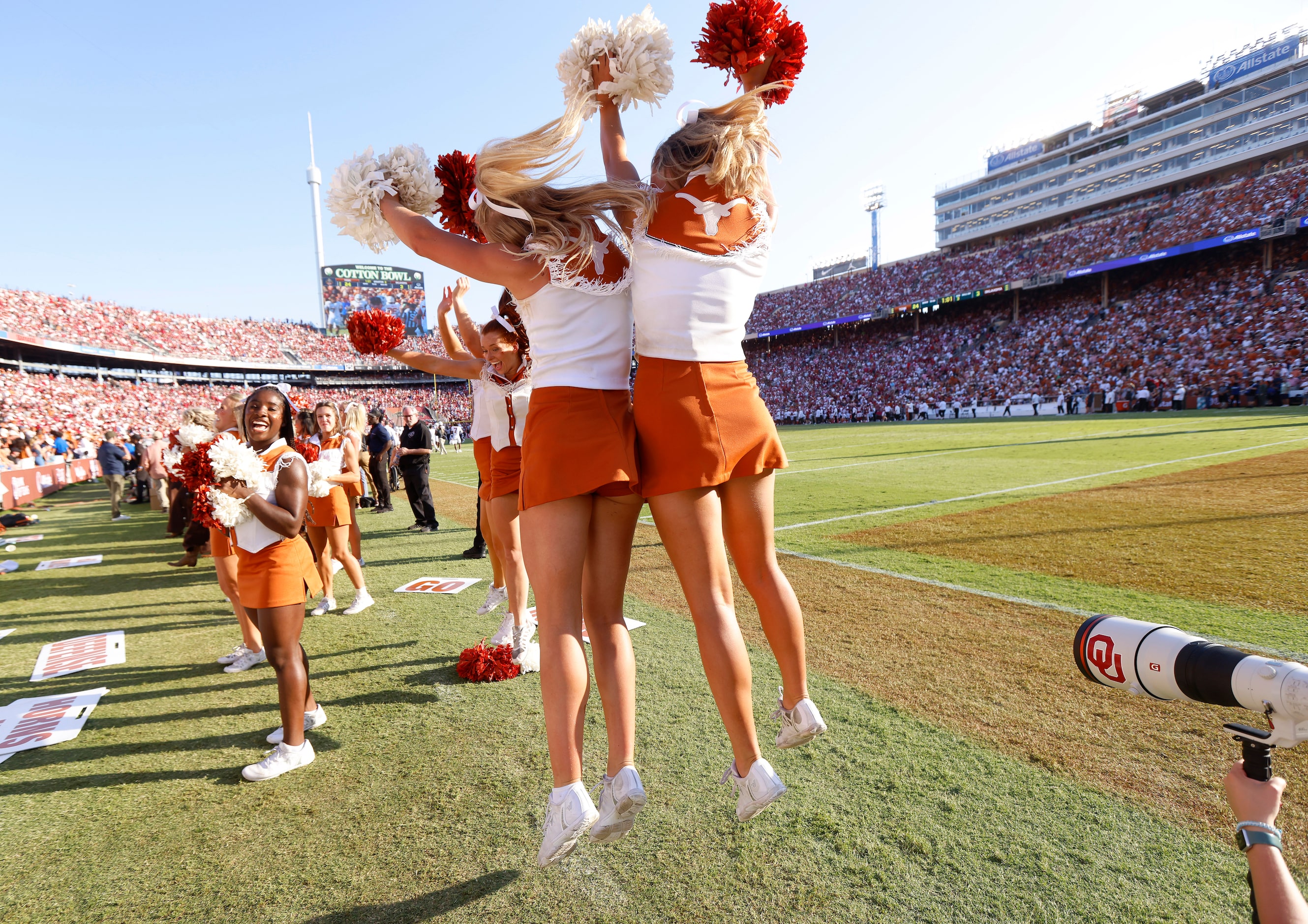 A pair of Texas Longhorns cheerleaders hip bump after the team scored against the Oklahoma...