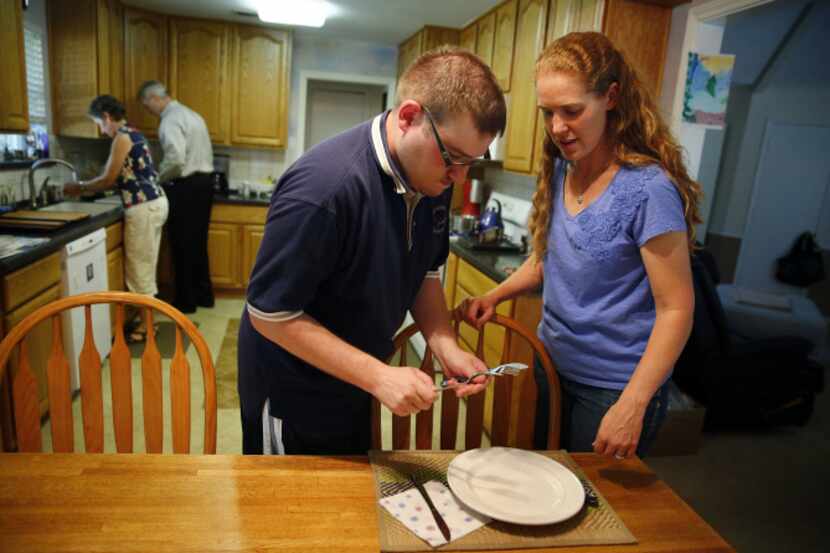 Mandy Dockweiler helps her brother Max Adamczyk set the table as they fix dinner at the home...