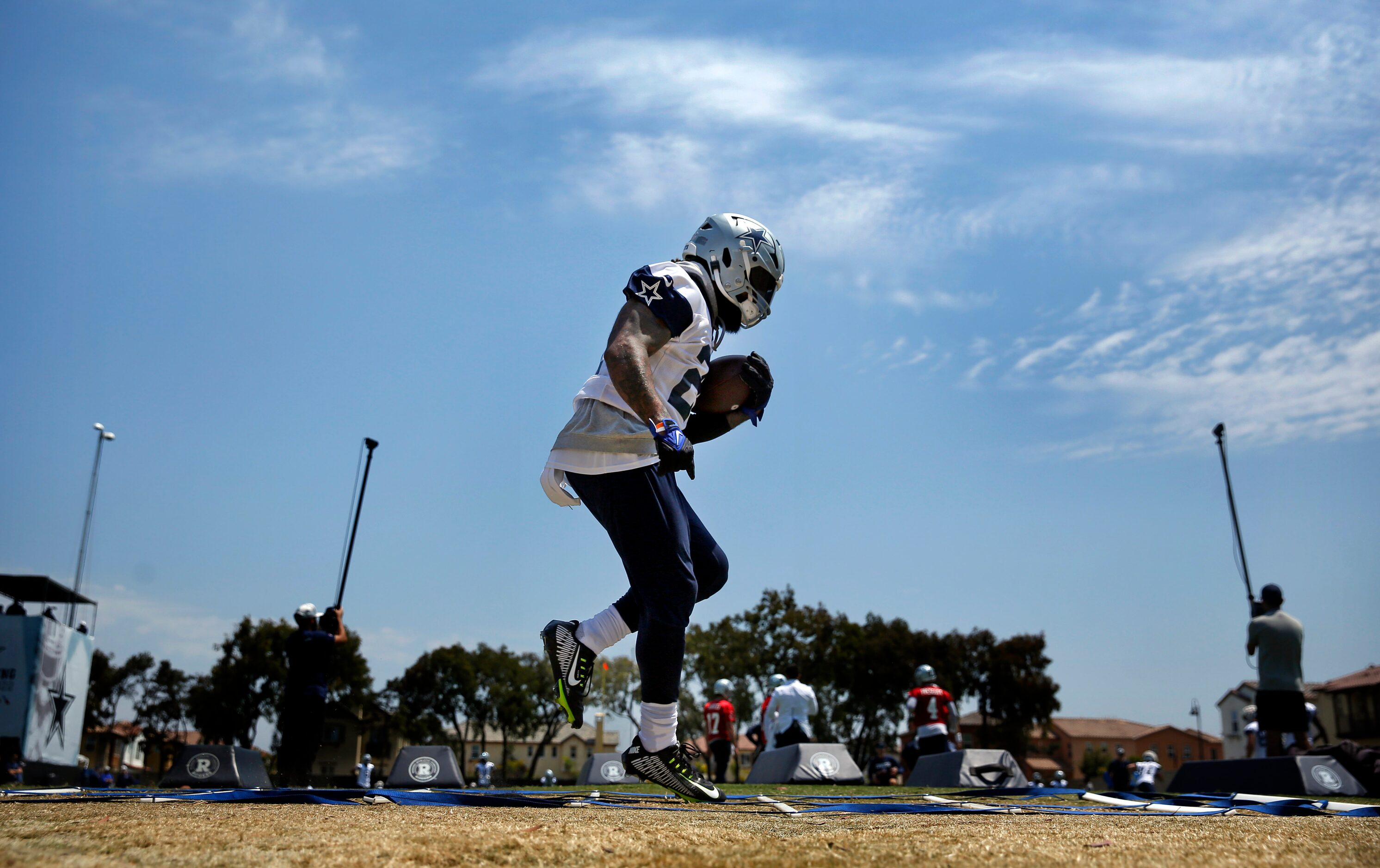 Dallas Cowboys running back Ezekiel Elliott (21) runs through step drills during the second...