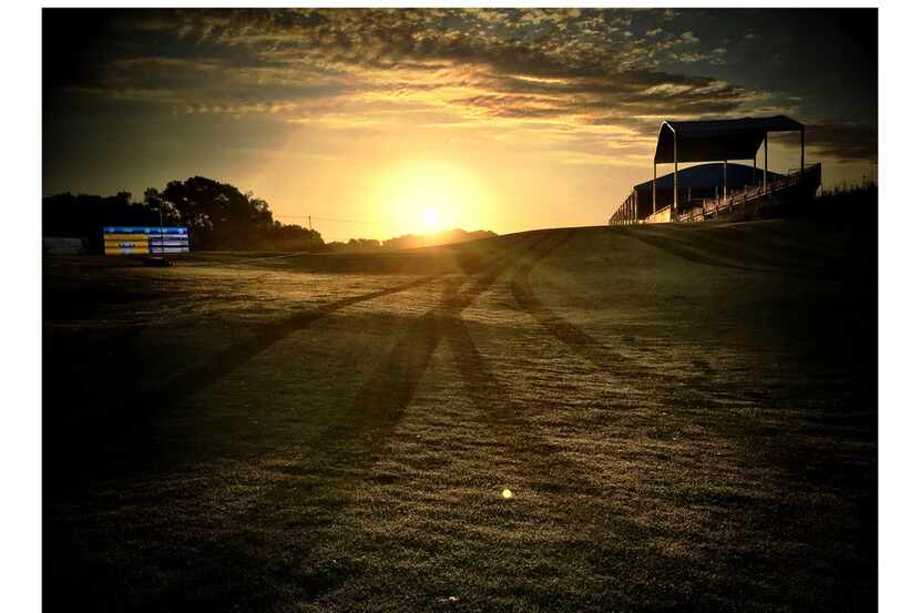 The sun rises over Trinity Forest where cart tracks are seen in the dew before play began....