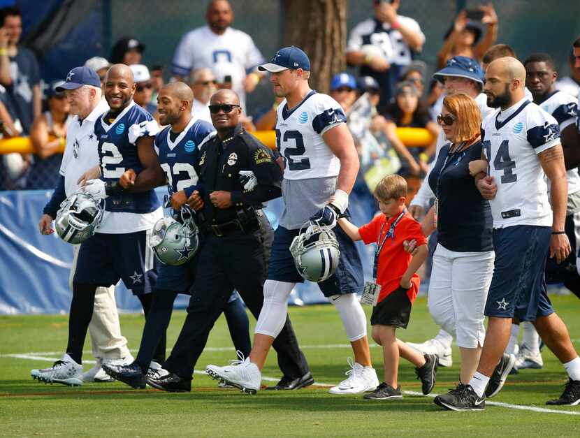 Dallas police Chief David Brown (center) walked arm-in-arm with (from left) Dallas Cowboys...